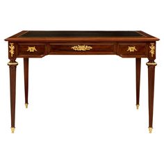 an antique desk with gold trimmings and drawers