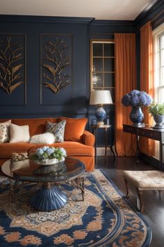 a living room with blue walls and orange couches in front of two windows, an area rug on the floor