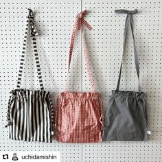 three purses hanging on the wall in front of polka dot pegboards with ribbons