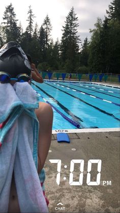 a person sitting in front of a swimming pool with a towel over their head and a helmet on his head