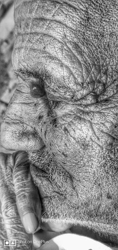 black and white photograph of an old man's face with wrinkles on it