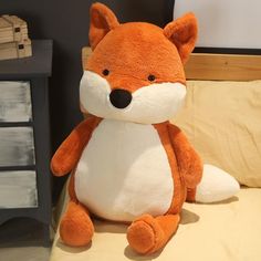 a stuffed fox sitting on top of a bed