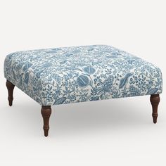 a blue and white ottoman with wooden legs