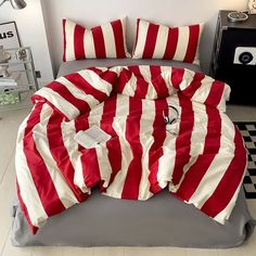 a red and white striped comforter on a bed