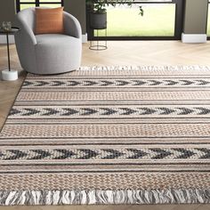 a living room with a chair and rug on the floor