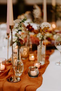 the table is set with candles, vases and other decorative items for an elegant dinner