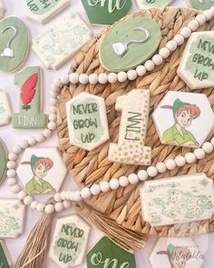 some decorated cookies are sitting in a wicker basket on top of a white table