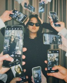 a group of people holding up cell phones in front of each other with photos on them