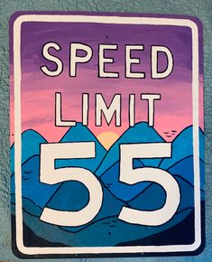 a speed limit sign with mountains in the background