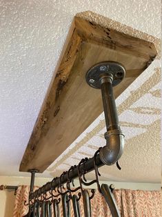 an old pipe is hanging from the ceiling in front of some hooks and umbrellas