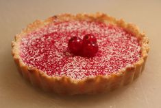 a pastry with powdered sugar on it and two cherries sitting on top of it