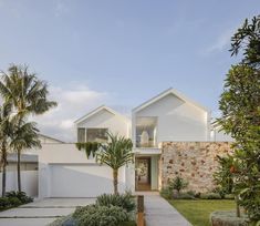 a white house with palm trees in the front yard and walkway leading up to it