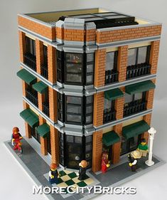 a building made out of legos with people standing in front and on the outside