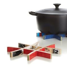 a black pot sitting on top of a table next to pieces of wood and magnets