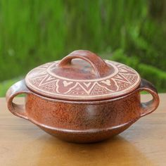 a brown pot sitting on top of a wooden table