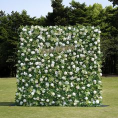 an artificial garden wall with white flowers on it's sides and the word love spelled in gold