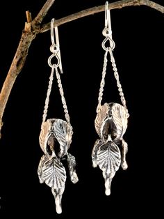 "Our Iris is in full bloom and it makes a lovely pair of earrings. This beautiful Iris flaunts curvaceous frilled petals and the stem is detailed with unfolding leaves. It is cast in sterling silver and is 1 3/8\" long and 1/2\" across. A chain slips through side openings between the petals and hangs from the ear wire. Bringing this design to fruition was fraught with technical challenges but I am thrilled with how it turned out. Creating an intricate design with an open center is difficult so t Silver Floral Jewellery, Nature-inspired Drop Flower Earrings For Pierced Ears, Nature-inspired Dangle Flower Earrings, Nature-inspired Dangle Earrings With Flower Charm, Iris Earrings, Iris Jewelry, Bohemian Jewels, Victorian Earrings, Gift For Gardener