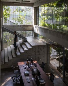 a man is walking up the stairs in an office with wooden desks and chairs