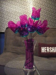 a vase filled with purple flowers sitting on top of a table next to a couch