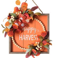 a sign that says happy harvest hanging from a rope with leaves and berries around it