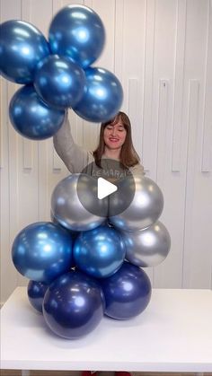 a woman standing on top of a pile of balloons