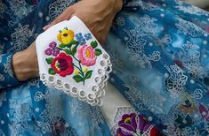 a close up of a person's hand holding a piece of cloth with flowers on it