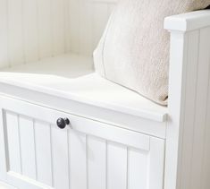 a close up of a white bench with a pillow on it's backrest