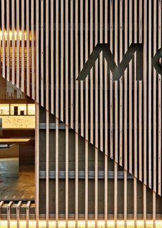 the entrance to an office building with wooden slats and metal bars on the wall