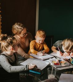 a group of people sitting around a table writing