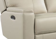 a beige leather reclining sofa with buttons on the armrests and head rest