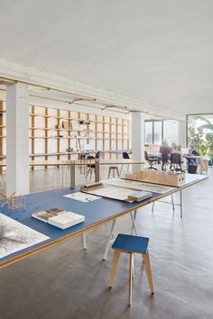 an open room with tables and chairs in front of bookshelves on the wall