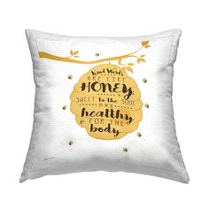 a white pillow with gold lettering on it and a tree branch in the background that says,