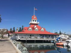 a boat dock with boats docked in the water and a flag on top of it