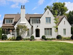 a large white house sitting on top of a lush green field