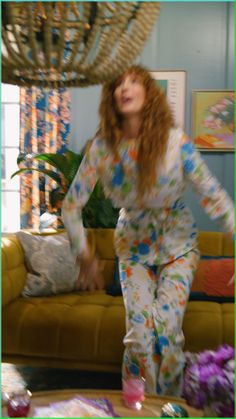 a woman in pajamas is dancing on the couch