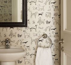 a white sink sitting under a bathroom mirror next to a wall mounted faucet