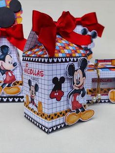 mickey mouse gift boxes with red bows and tags on the front, set against a white background