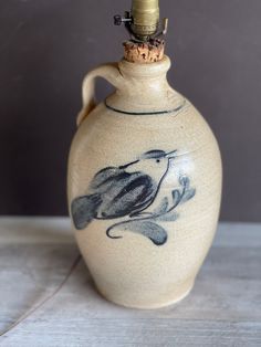 a ceramic vase with a bird painted on it