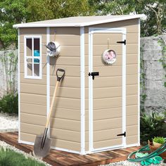 a garden shed with a shovel, rake and flower pot