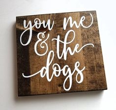 a wooden sign that says you me and the dogs with white lettering on it's side