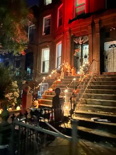 the stairs are lit up with christmas lights and decorations on each step in front of an apartment building