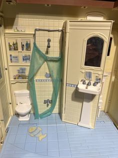 a doll house bathroom with sink, toilet and shower