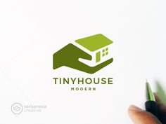 the logo for tinyhouse modern is shown in front of a hand holding a pencil