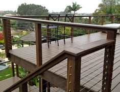 a wooden deck with railings and chairs on it