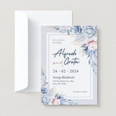 a wedding card with blue flowers and greenery on the front, in white envelope