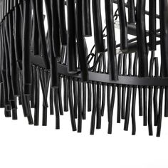 an abstract sculpture made out of black sticks and metal rods on a white background with no one in the photo