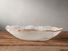 a white bowl sitting on top of a wooden table