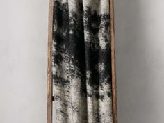 a black and white blanket hanging on a wooden ladder