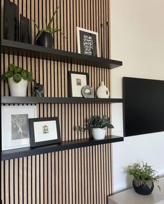 the wall is decorated with black and white striped wallpaper, potted plants and framed pictures