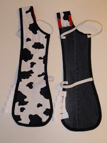 two oven mitts made out of old jeans with cow print on them, one is black and the other is white